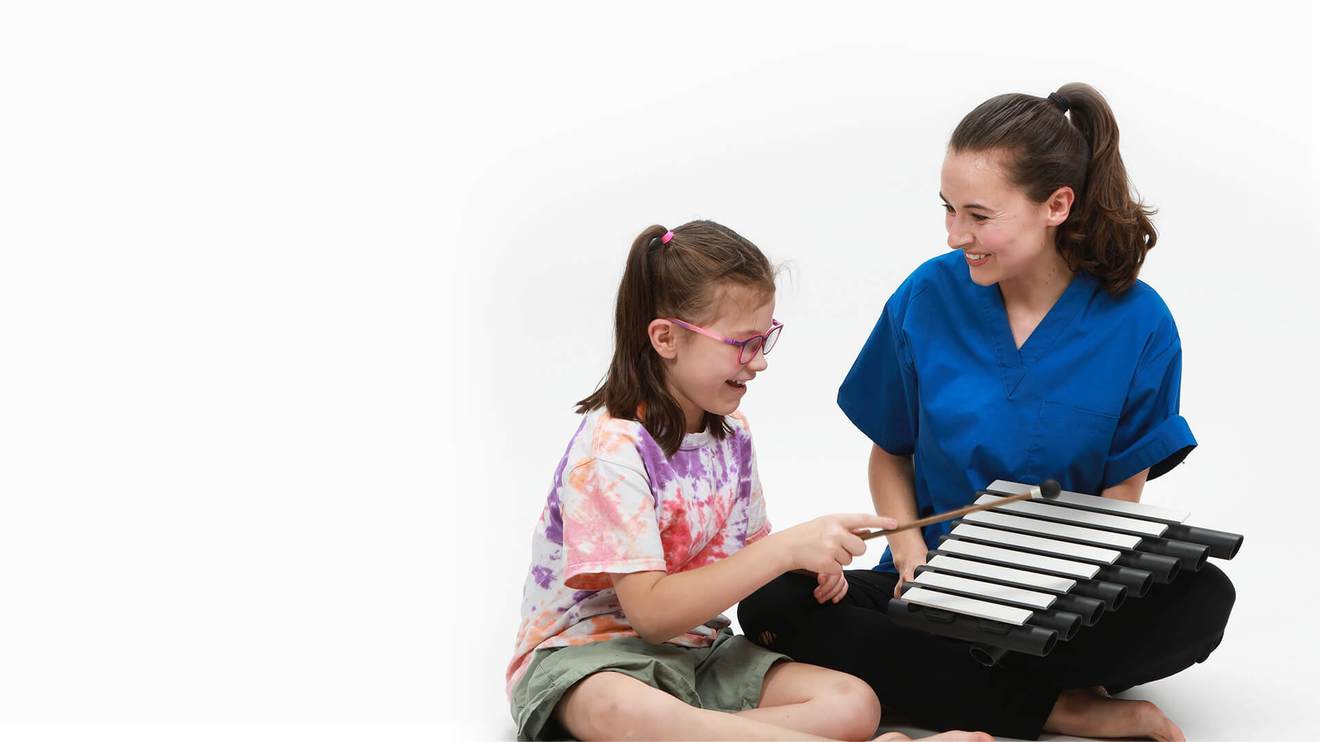 caregiver-playing-musical-instrument-with-girl